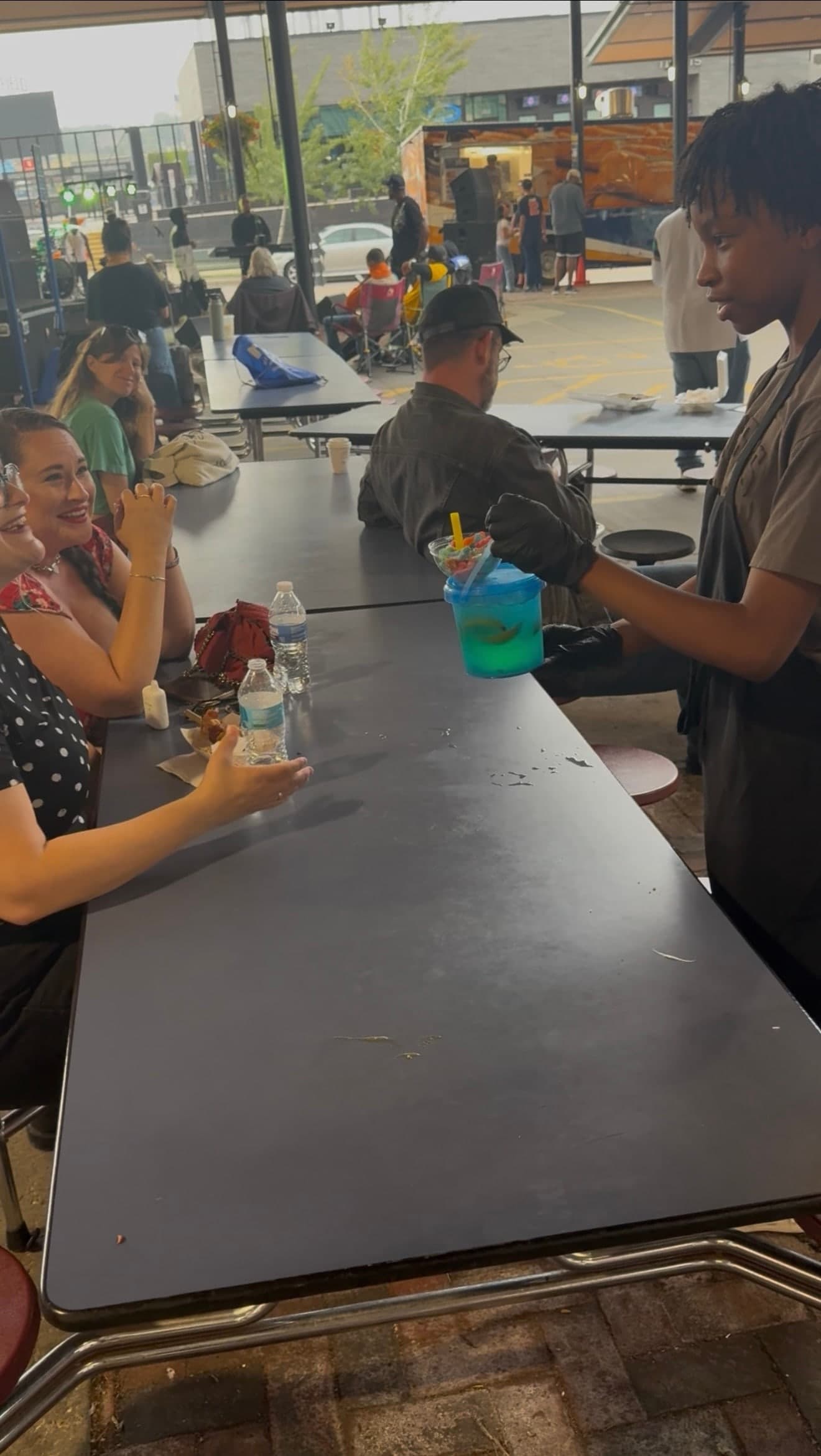 A lit blue bucket being handed across the table to waiting guests